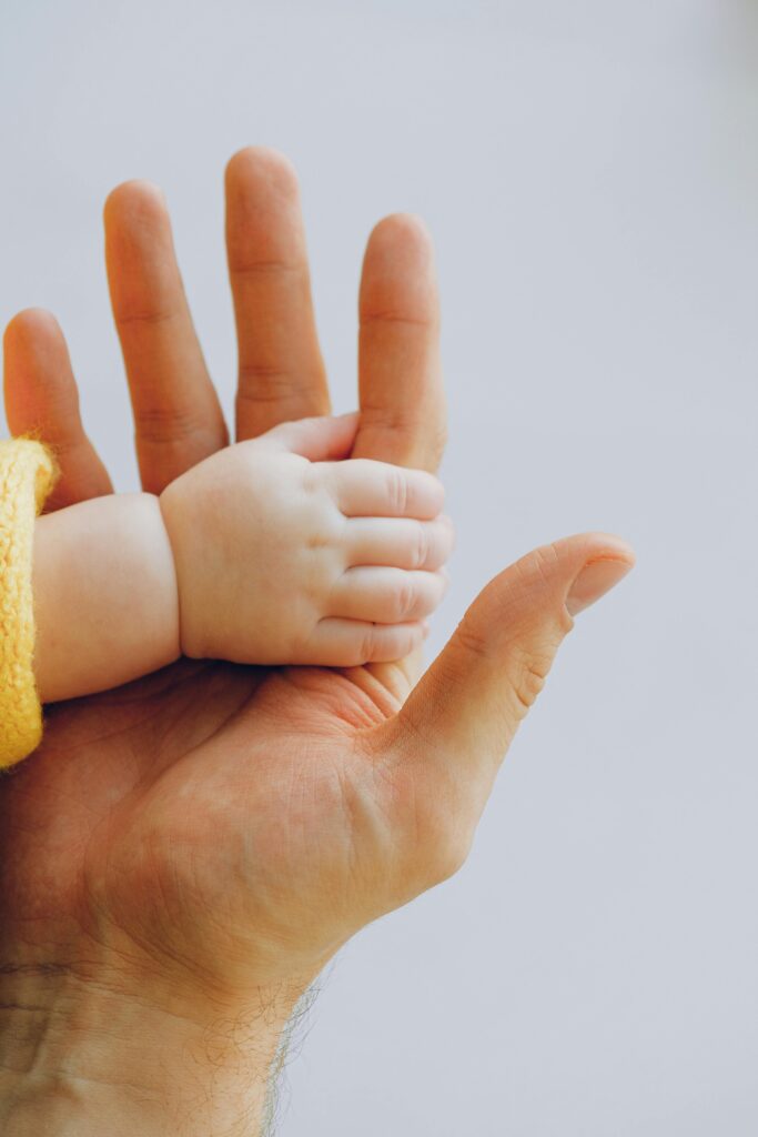 pexels-photo-3845456-3845456-1 Tender moment captured between a baby and parent's hands symbolizing love and trust.